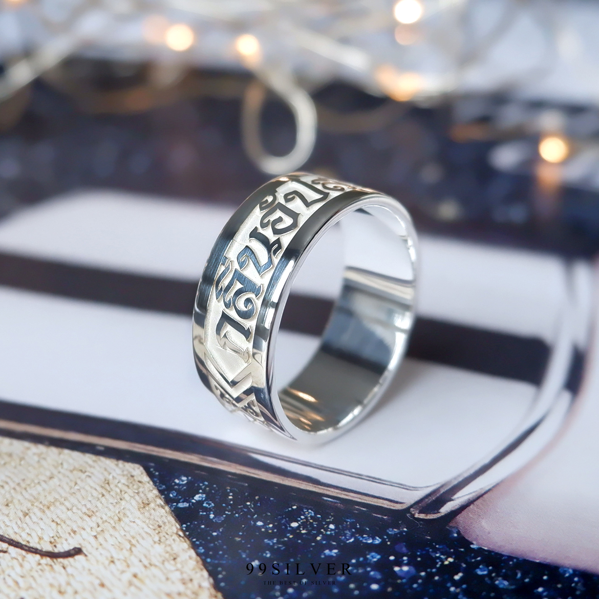 แหวนนามสกุลเงินแท้หน้ากว้าง 8-10 มิลลิเมตร ผิวเรียบ พื้นหลังพ่นทราย พร้อมแกะลายไทย