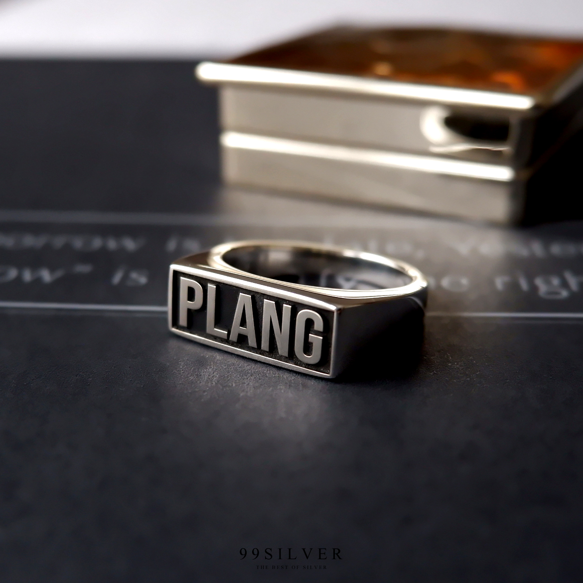 แหวนนามสกุลหน้าเหลี่ยม 8x18 มิลลิเมตร แกะลายออกแบบอักษร พื้นหลังลงยาสี