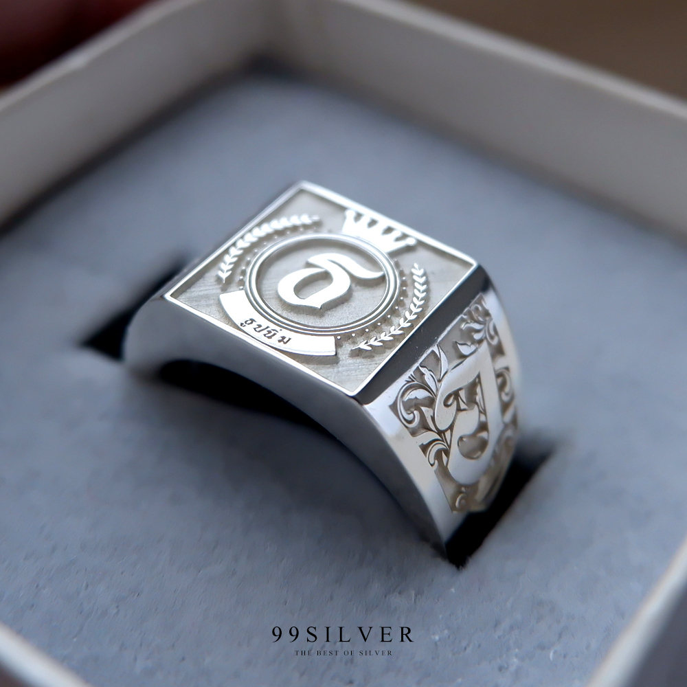 แหวนนามสกุลหน้าเหลี่ยม 11 มิลลิเมตร เนื้อตันแกะลายออกแบบอักษร พื้นหลังพ่นทราย
