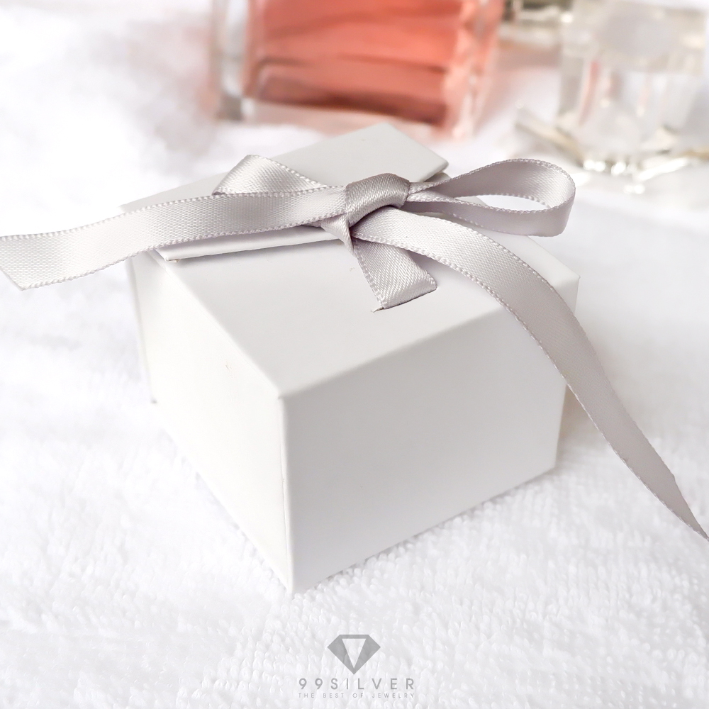 กล่องใส่แหวนสีขาวสี่เหลี่ยม  มีริบบิ้นผูกโบว์สำหรับยึดฝา ข้างในบุด้วยสปั้นช์นิ่มสีดำ