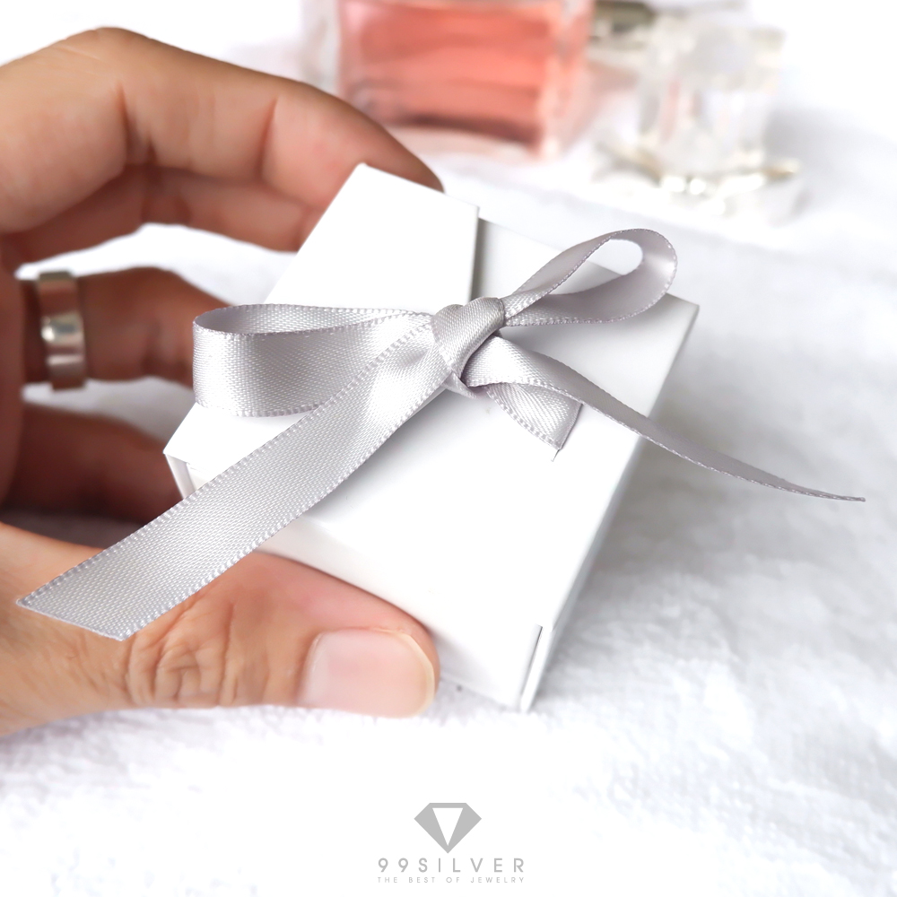 กล่องใส่แหวนสีขาวสี่เหลี่ยม  มีริบบิ้นผูกโบว์สำหรับยึดฝา ข้างในบุด้วยสปั้นช์นิ่มสีดำ