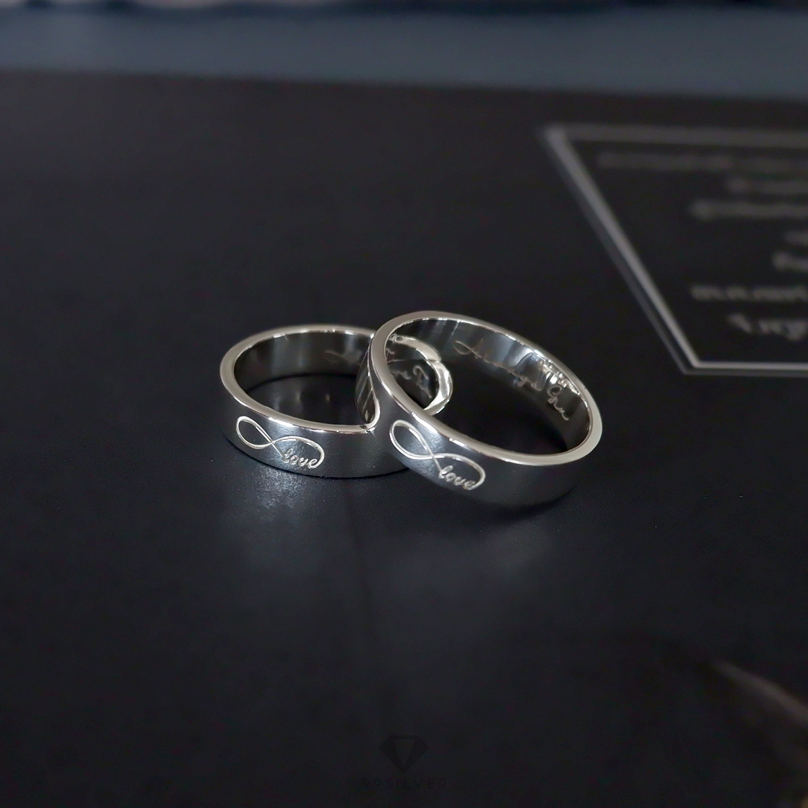  แหวนเงินแท้ หน้ากว้าง 4 มิลลิเมตร ผิวเรียบเงาทรงแบน สลักอักษรสีขาวพ่นทราย