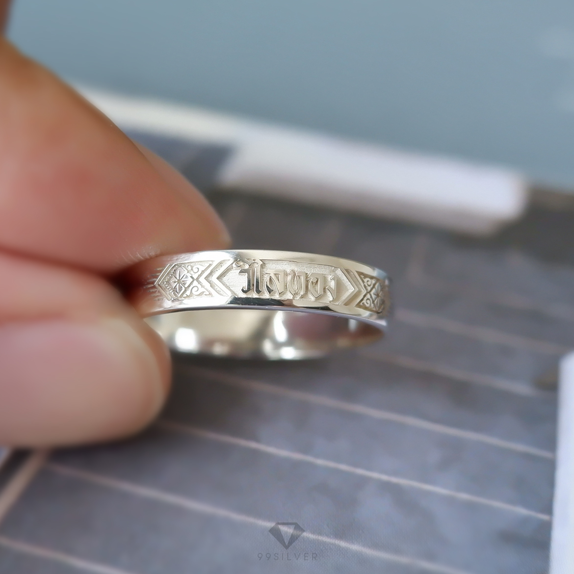 แหวนนามสกุลเงินแท้หน้ากว้าง 4 มิลลิเมตร ผิวเรียบ พื้นหลังพ่นทราย พร้อมแกะลายไทย