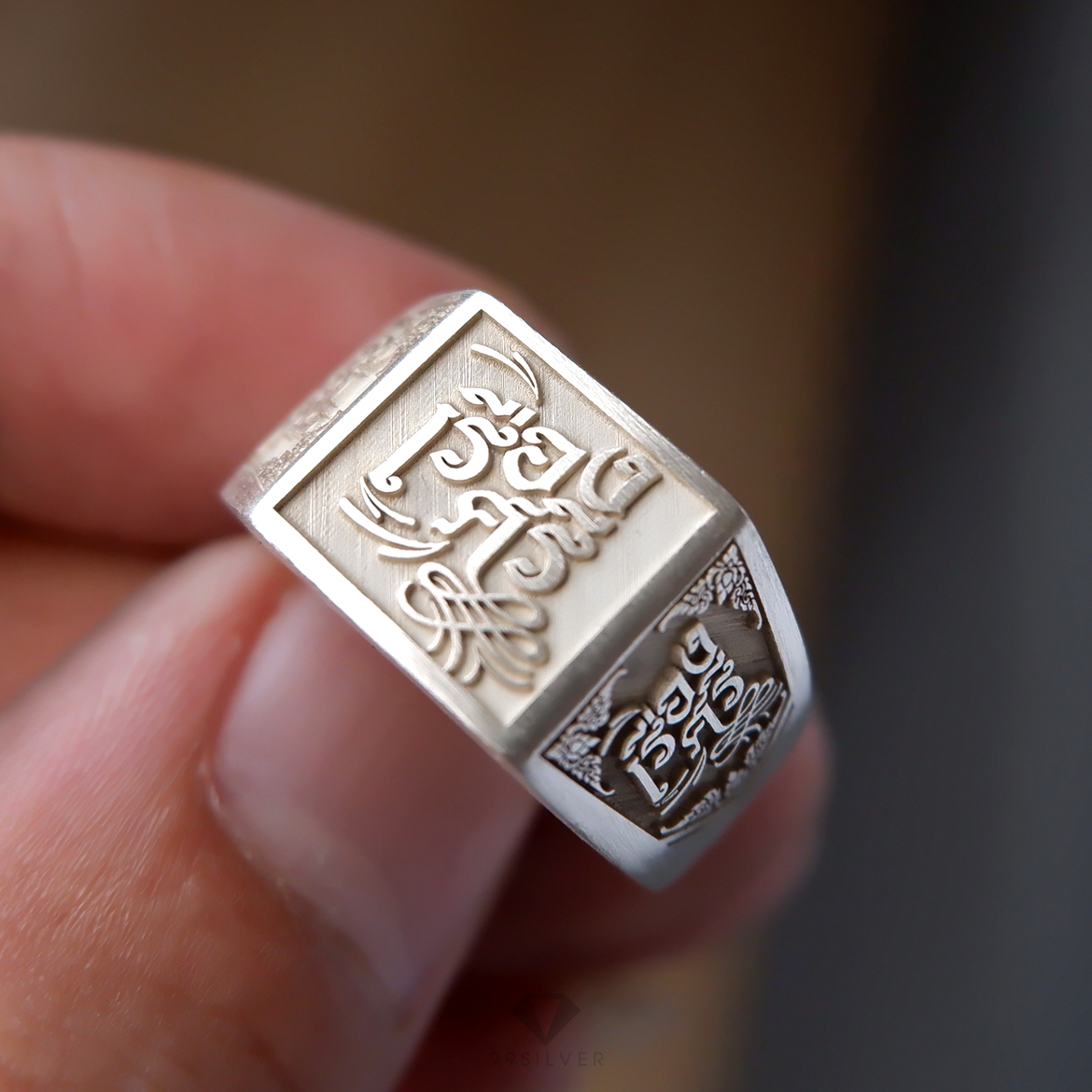 แหวนนามสกุลหน้าเหลี่ยม 11 มิลลิเมตร เนื้อตันแกะลายออกแบบอักษร พื้นหลังพ่นทราย