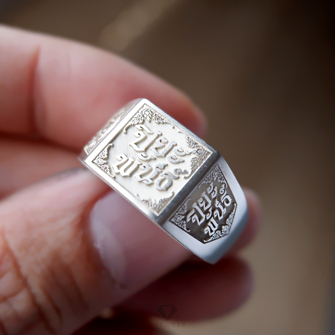 แหวนนามสกุลหน้าเหลี่ยม 11 มิลลิเมตร เนื้อตันแกะลายออกแบบอักษร พื้นหลังพ่นทราย