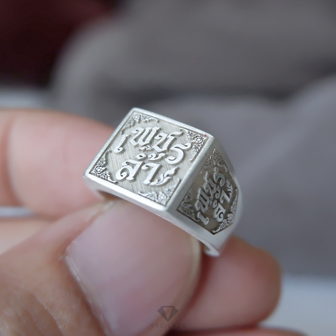 แหวนนามสกุลหน้าเหลี่ยม 11 มิลลิเมตร เนื้อตันแกะลายออกแบบอักษร พื้นหลังพ่นทราย